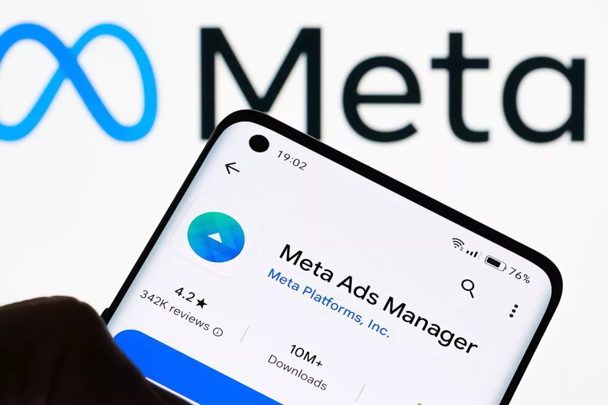 Application Meta Ads Manager affichée sur un smartphone devant le logo Meta