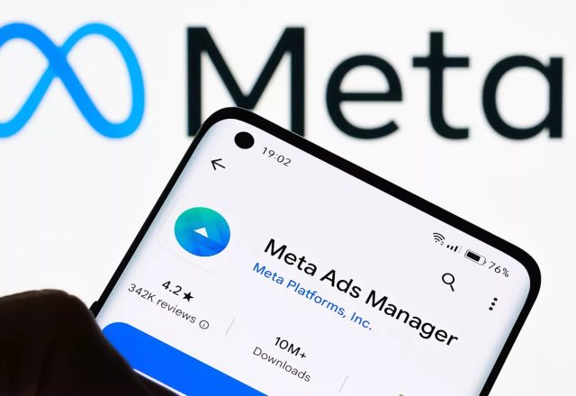 Application Meta Ads Manager affichée sur un smartphone devant le logo Meta