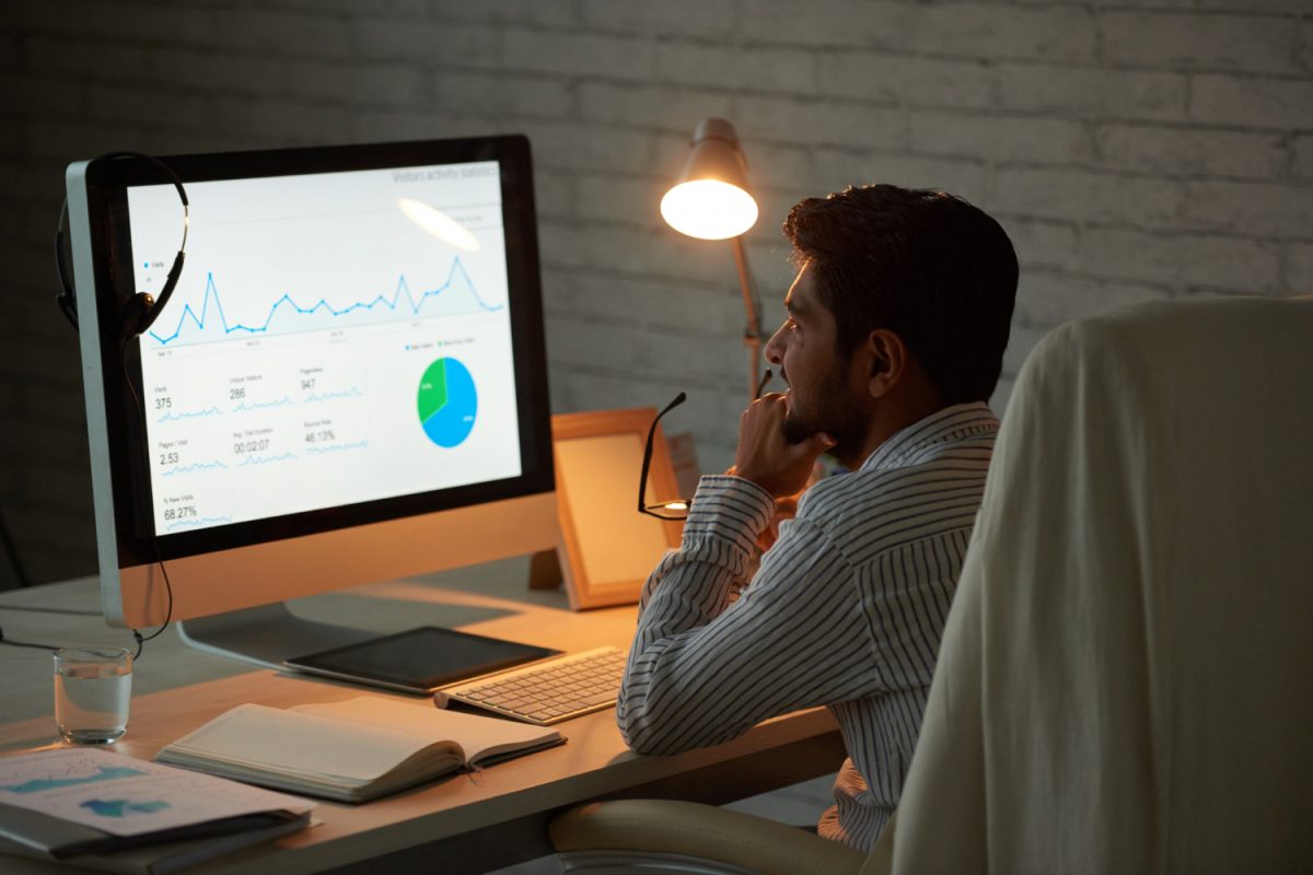 Responsable marketing analysant la courbe de trafic de son site sur un tableau de bord d'audience