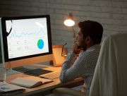 Responsable marketing analysant la courbe de trafic de son site sur un tableau de bord d'audience