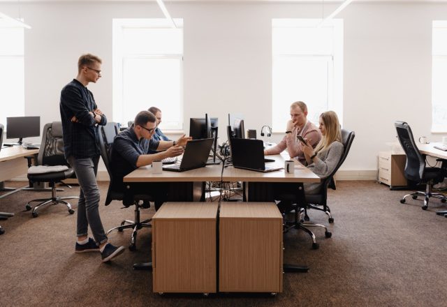 Équipe de prestataire réunie autour d’ordinateurs portables dans un open space