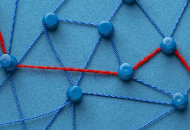 Budget netlinking : des punaises reliées par des fils bleus, dont un fil rouge trace le chemin prioritaire entre quelques nœuds