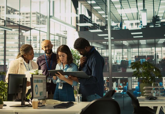 Équipe réunie autour de tablettes dans un open space pour comparer des prestataires