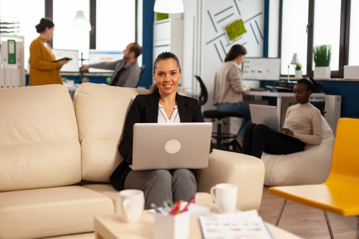 Consultante souriante travaillant sur un ordinateur portable dans un open space