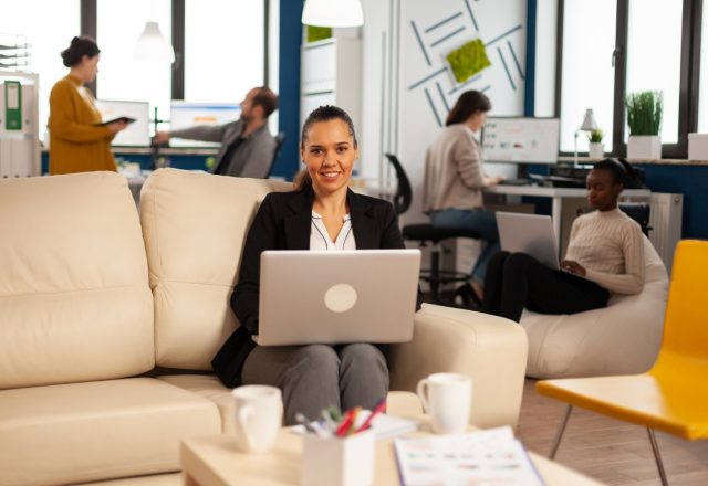 Consultante souriante travaillant sur un ordinateur portable dans un open space