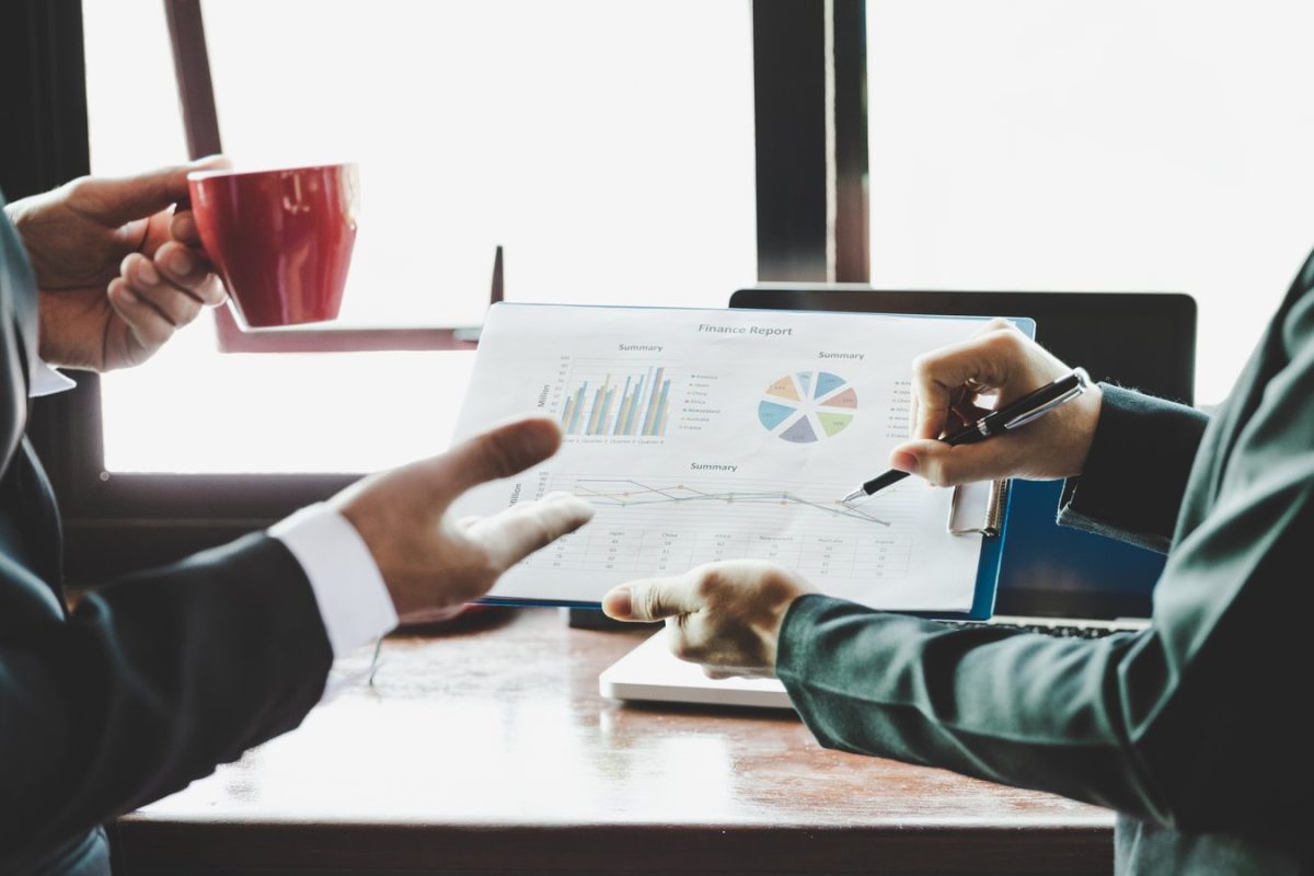 Deux collaborateurs analysant un rapport financier avec graphiques, illustration des données propriétaires publiées