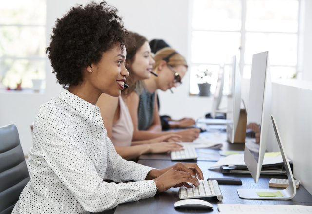 Trois téléconseillères au casque devant leurs écrans dans un bureau lumineux