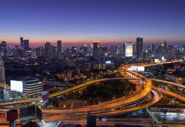 Skyline d’une métropole de nuit, voies rapides illuminées
