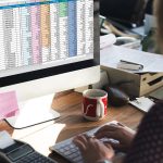 Collaboratrice saisissant des données comptables dans un tableur