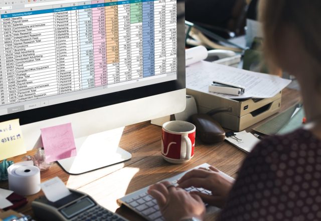 Collaboratrice saisissant des données comptables dans un tableur