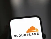 Smartphone affichant le logo Cloudflare tenu en main sur fond sombre