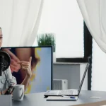Créatrice équipée d’un casque et d’un micro enregistrant une vidéo face à une caméra dans son studio