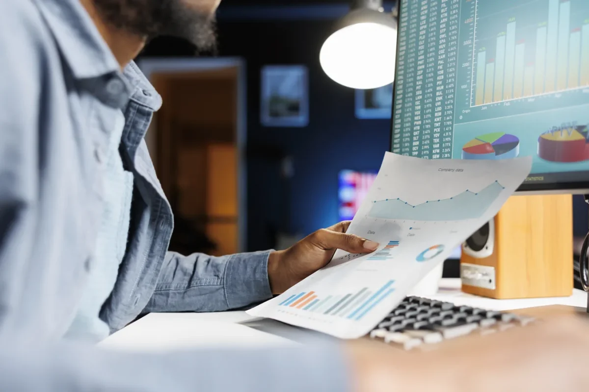Contrôleur de gestion externalisé analysant les graphiques d’un reporting financier devant son écran