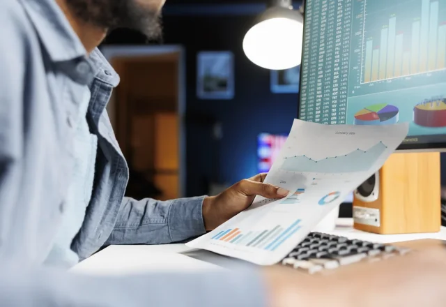 Contrôleur de gestion externalisé analysant les graphiques d’un reporting financier devant son écran
