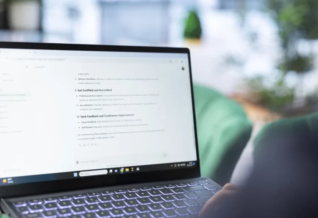 Personne qui travaille sur un ordinateur portable affichant une conversation avec un assistant d’IA