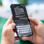 Mains tenant un smartphone affichant une conversation avec ChatGPT