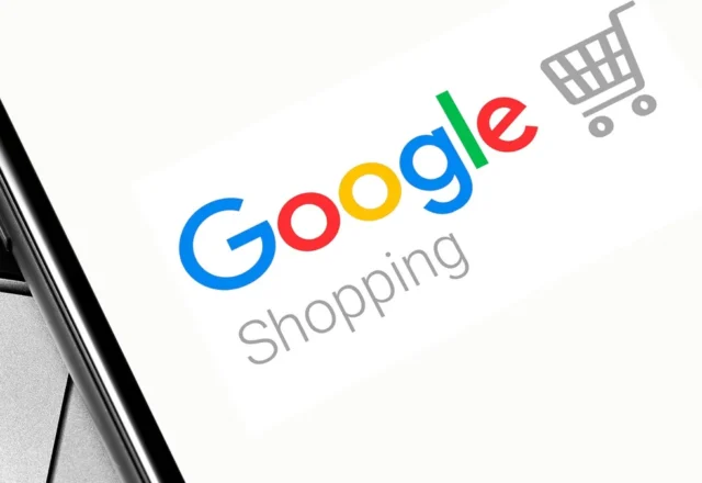 Logo Google Shopping affiché sur l'écran d'un smartphone posé sur un ordinateur portable