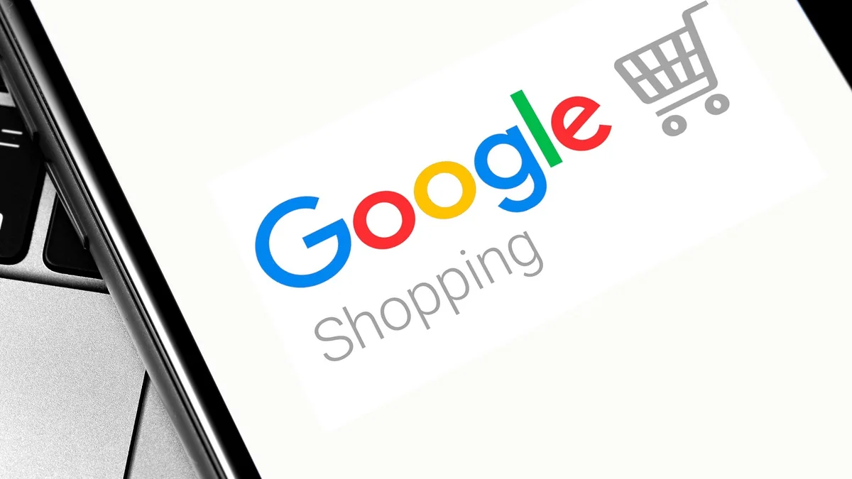 Logo Google Shopping affiché sur l'écran d'un smartphone posé sur un ordinateur portable