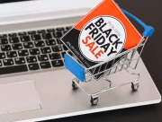 Mini chariot de supermarché contenant une affiche « Black Friday Sale », posé sur le clavier d’un ordinateur portable