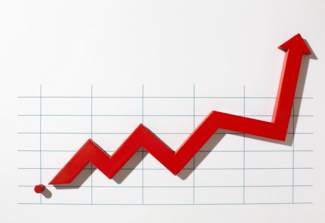 Flèche rouge en zigzag qui monte sur une grille de graphique