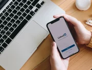 Smartphone affichant l'écran d'accueil de LinkedIn à côté d'un ordinateur portable